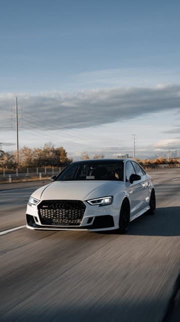A white Audi sedan on the highway