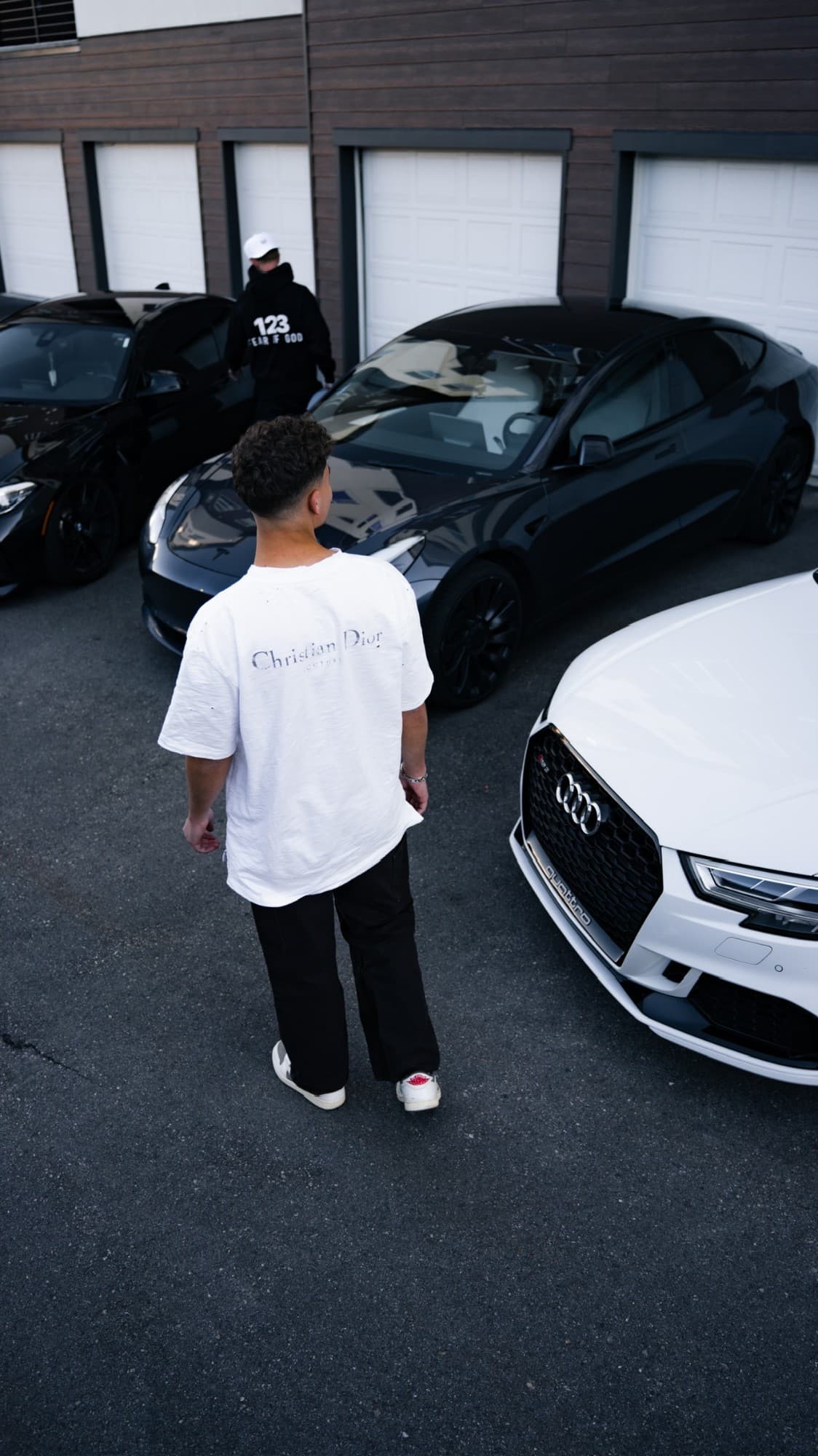 Walking past a row of cars outside the garages